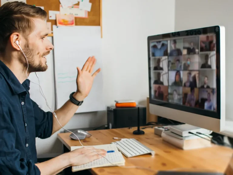 A professional waves to a class of students on a video call